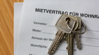 Wohnen wird immer teurer: Ein Mietvertrag für Wohnräume liegt zusammen mit Wohnungsschlüsseln auf einem Tisch.